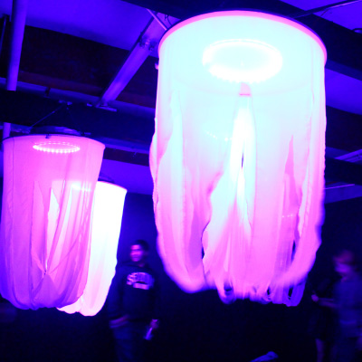 A image of large light and fabric art installations in a dark room project.
