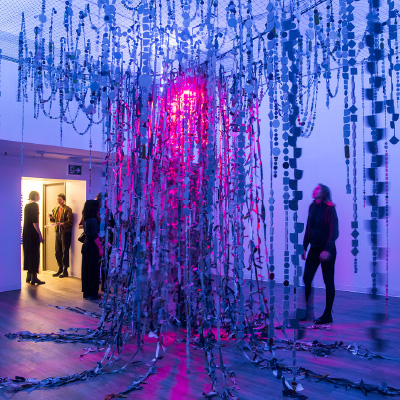 A large installation made of pieces of fabric strung up into a tree shape in an art gallery project.